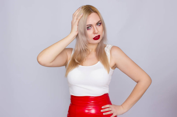 Blonde woman in red leather skirt and white shirt - Foto, imagen