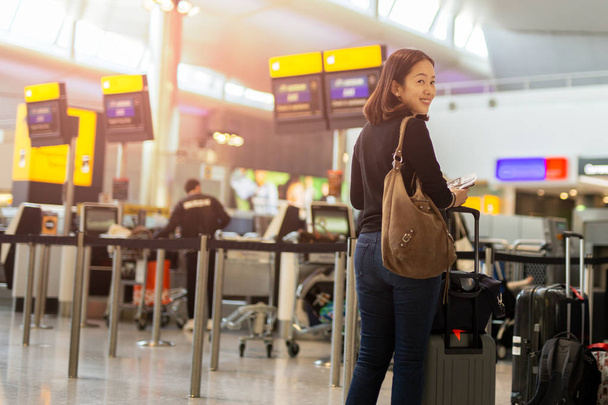 Mujer feliz con sonrisa mano sosteniendo pasaporte y tarjeta de embarque
. - Foto, Imagen