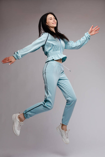 Happy brunette jumping and laughing in studio - Photo, Image