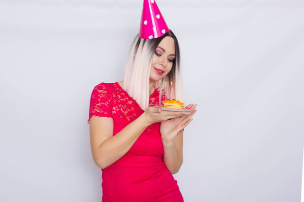 Blond in party hat holding cake - Photo, image