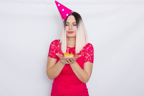 Blond in party hat holding cake - Zdjęcie, obraz