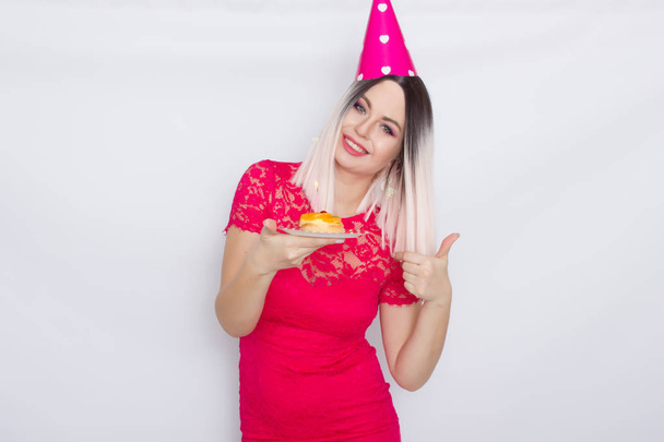 Blond in party hat holding cake - Fotó, kép
