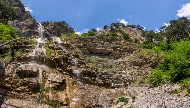 Touristen am Fuße des Wasserfalls uchan-su, Republik Krim - Foto, Bild