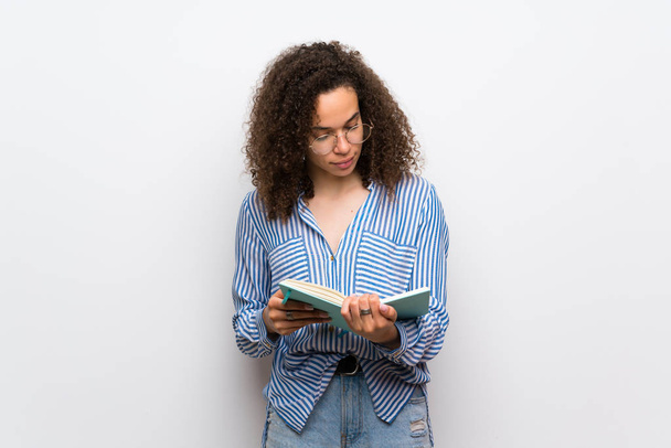 Δομινικανή γυναίκα με ριγέ πουκάμισο κρατά ένα βιβλίο και να απολαύσετε την ανάγνωση - Φωτογραφία, εικόνα