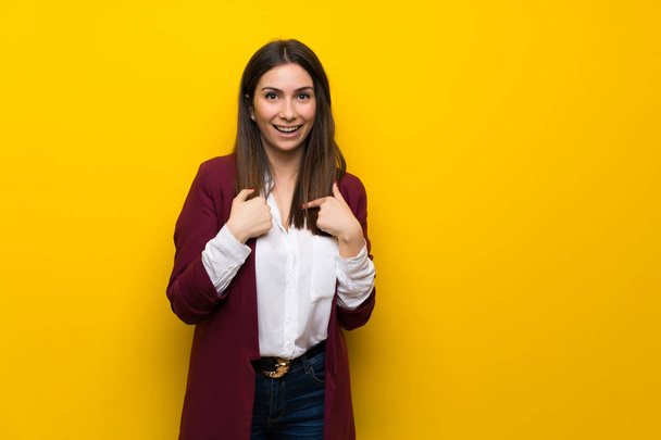 Young woman over yellow wall with surprise facial expression - Foto, afbeelding