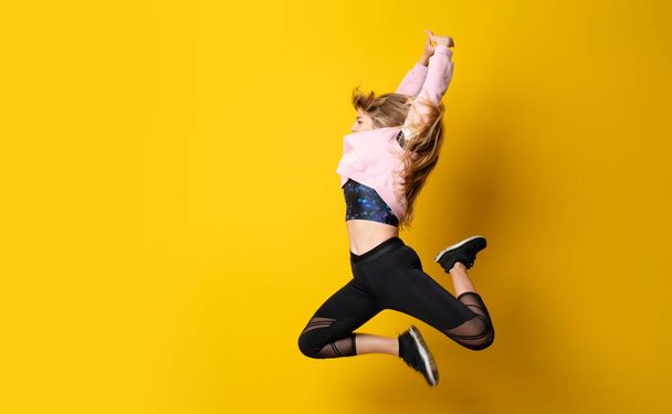 Bailarina urbana bailando sobre fondo amarillo aislado y saltando
 - Foto, imagen
