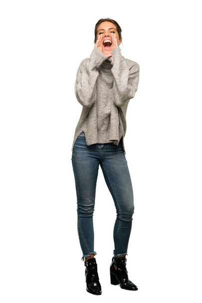 A full-length shot of a Blonde woman with turtleneck shouting and announcing something over isolated white background - Foto, Imagem