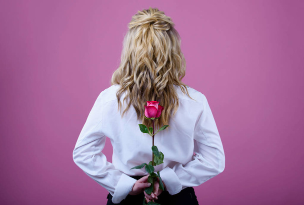 Beatiful girl with a pink rose on a pink background. - Photo, Image