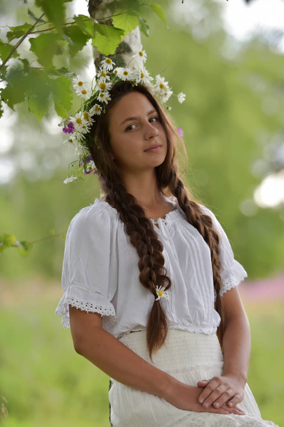 sweet Russian girl girl in a white birch in the summer, with a w - 写真・画像