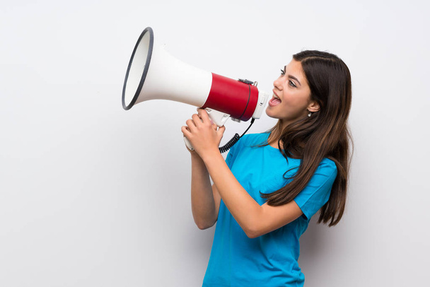 Teenager girl with blue shirt shouting through a megaphone - Фото, зображення