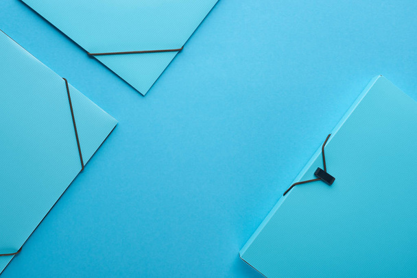 vue du dessus des reliures en papier isolées sur bleu avec espace de copie
 - Photo, image