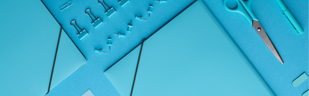 kağıt bağlayıcılar ve mavi izole çeşitli kırtasiye panoramik çekim  - Fotoğraf, Görsel