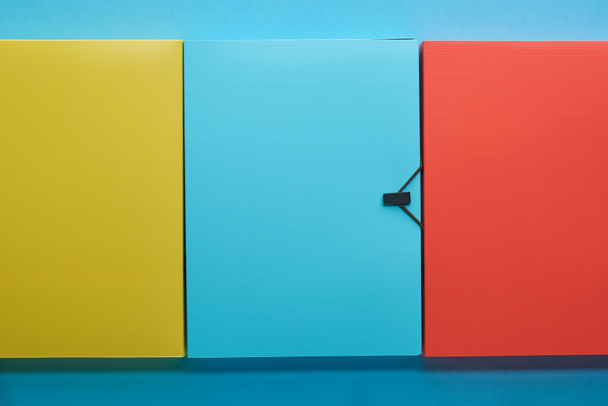 top view of colorful office paper folders on blue - Foto, imagen