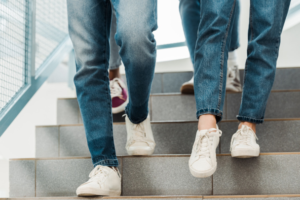 partial view of group of people in jeans on stairs - Photo, Image
