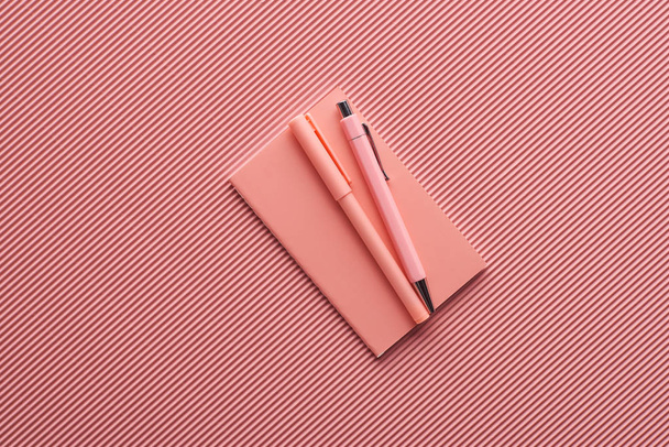 minimalistic background with pens and notebook on textured pink - Фото, зображення