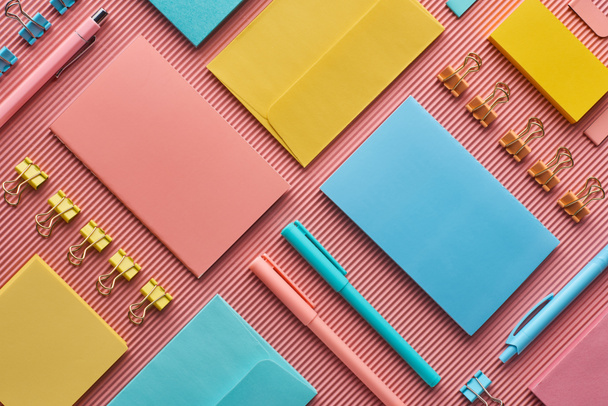 top view of colorful stationery supplies on pink  - Фото, изображение