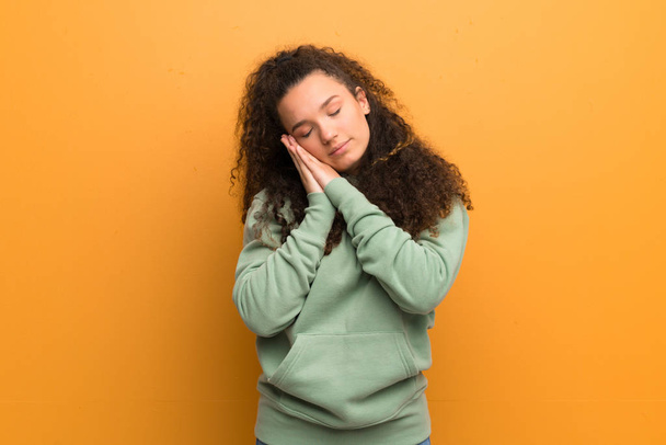 Teenager girl over ocher wall making sleep gesture in dorable expression - Photo, Image