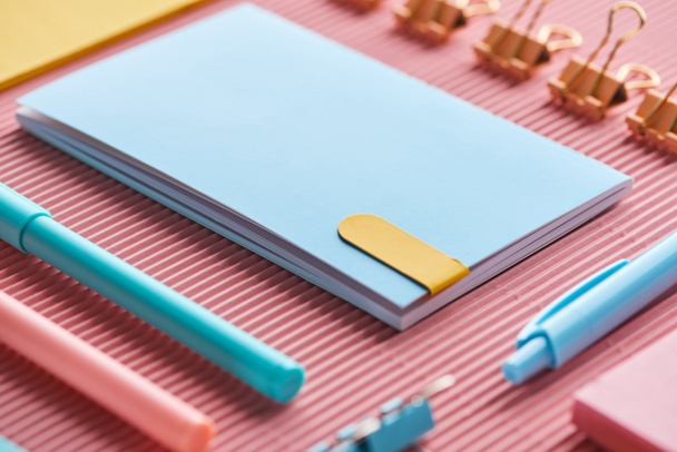 selective focus of notebook and colorful stationery supplies on pink  - Photo, Image
