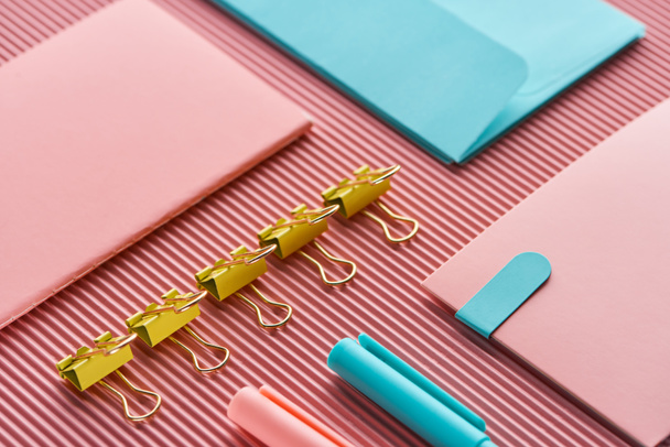notebook, paper clips and colorful stationery supplies on pink  - Fotografie, Obrázek