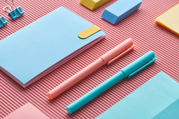 colorful pens, notebooks and erasers on pink - Photo, Image