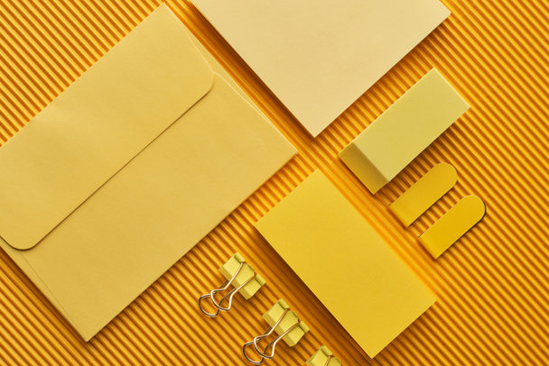vista superior de los suministros de papelería de oficina arreglados en amarillo
 - Foto, imagen
