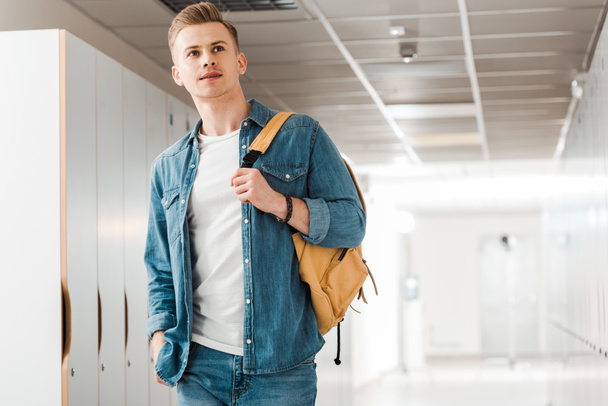 pensive student with backpack in corridor in university - Photo, Image