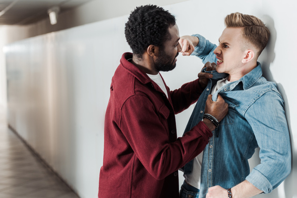 két multietnikus hallgató küzd az egyetemi folyosón - Fotó, kép