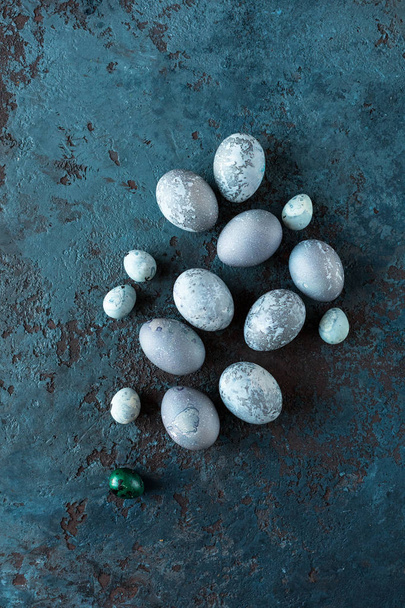 Composition with Easter eggs on a textured stone background. Copy space. Top view. - Fotoğraf, Görsel