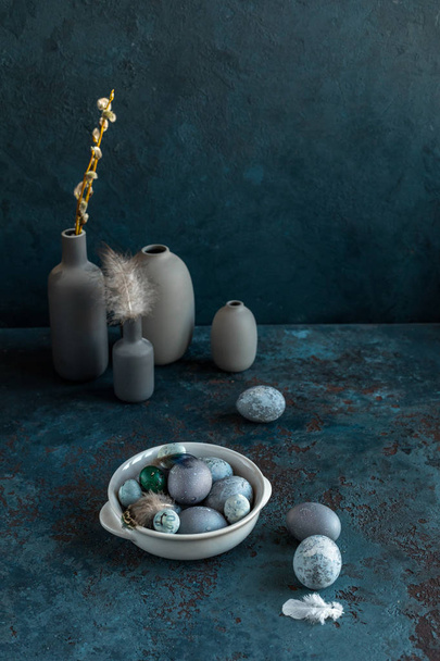 Composition of Easter eggs on a plate on a gray blue textured stone background. Copy space. Top view. - Foto, Imagem