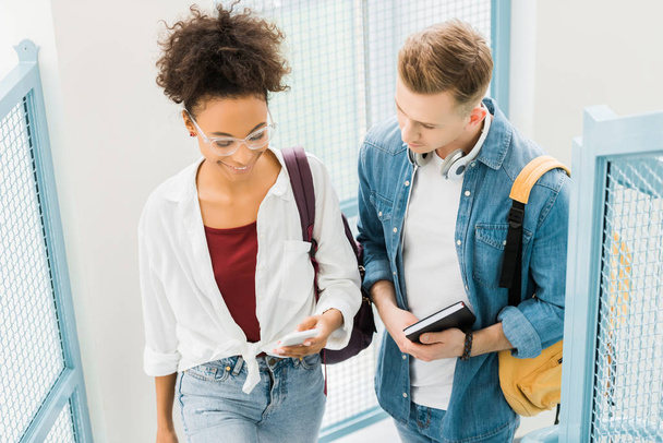 dos estudiantes multiculturales con portátil y smartphone en la universidad
 - Foto, Imagen