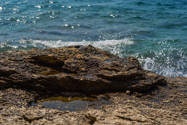 Ondas quebrando em uma praia de pedra em Murter, Croácia, Dalmácia
 - Foto, Imagem