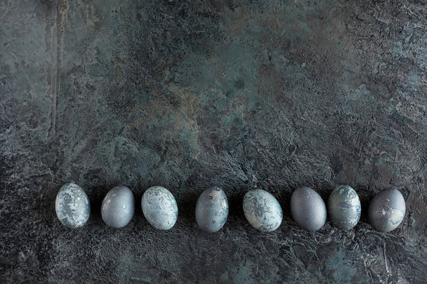 Composition with Easter eggs on a textured stone background. Copy space. Top view. - Foto, afbeelding