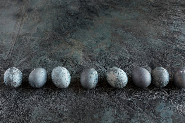 composition with futuristic Easter eggs on a textured stone background. Copy space. Top view. - Fotografie, Obrázek