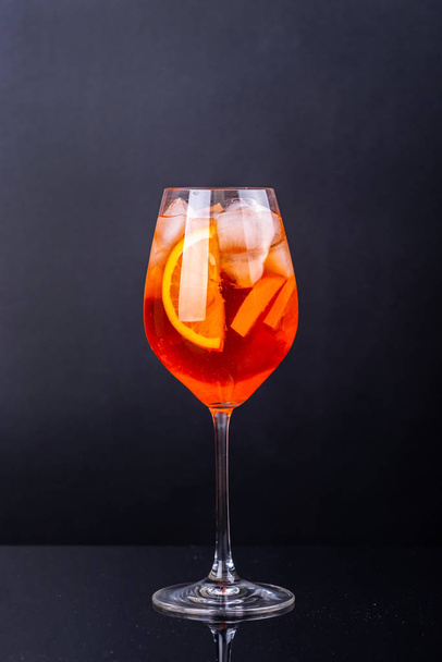 Aperol spritz cocktail in glass on black reflection background. - Photo, Image