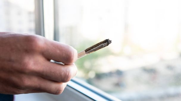 European man smokes joint with marijuana for medical purposes. Cannabis smoking in the world - Foto, Imagem