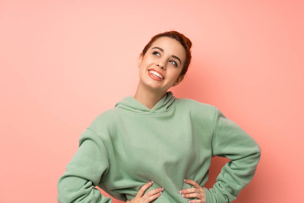 Young redhead woman with sweatshirt smiling - Foto, afbeelding
