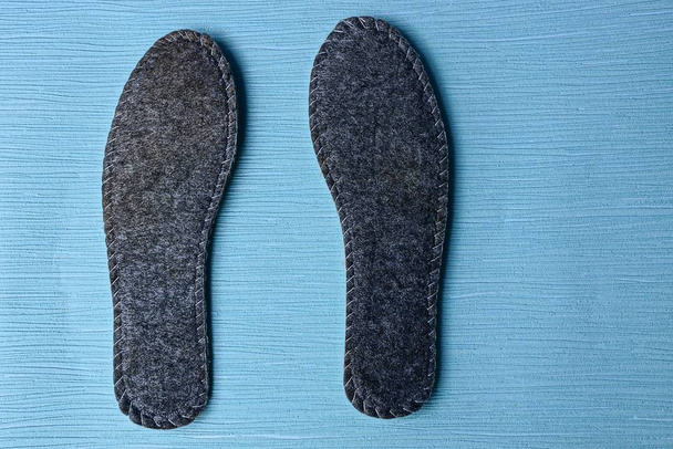 deux semelles intérieures grises pour chaussures sur fond bleu
 - Photo, image