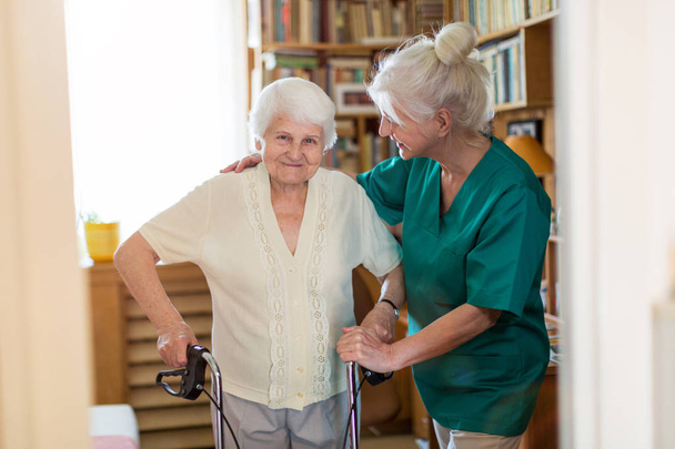 Senior vrouw met haar vrouwelijke verzorger - Foto, afbeelding