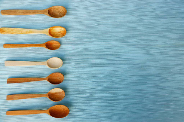 Set of brown wooden spoons on a blue table - Photo, Image