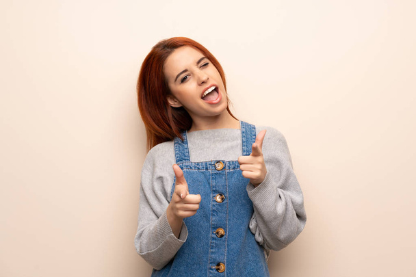 Young redhead woman over isolated background pointing to the front and smiling - Photo, Image