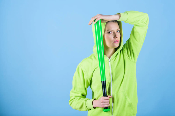 Sport game. Woman play baseball game or going to beat someone. Girl hooded jacket hold baseball bat blue background. Woman in baseball sport. Baseball female player concept. She is dangerous - Foto, Imagen