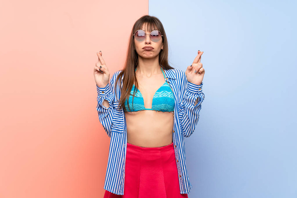 jonge vrouw in bikini met vingers kruisen en wensen de beste - Foto, afbeelding