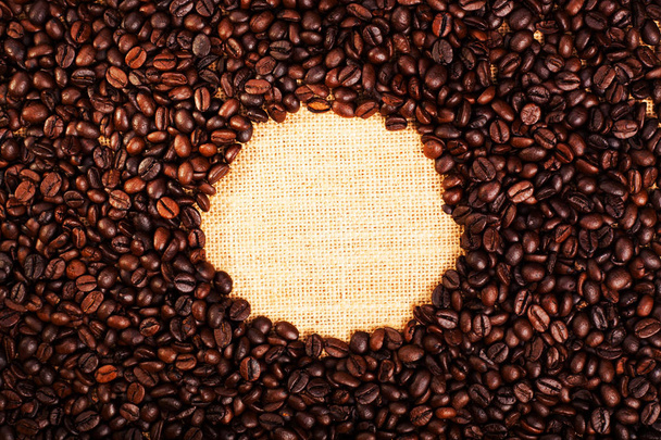 Жареный кофе в зернах вид сверху, с мешковатым фоном и текстурой с копировальным пространством
 - Фото, изображение