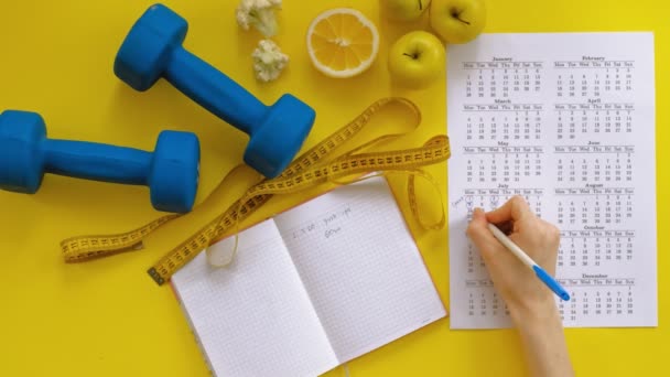 αθλητικό ημερολόγιο, υγιεινό φαγητό, γυρίσματα σε ένα κίτρινο φόντο πάνω όψη - Πλάνα, βίντεο