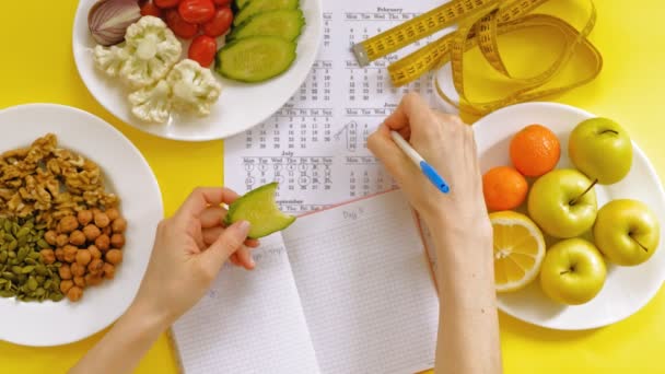 sports calendar, healthy food, shooting on a yellow background top view - Footage, Video