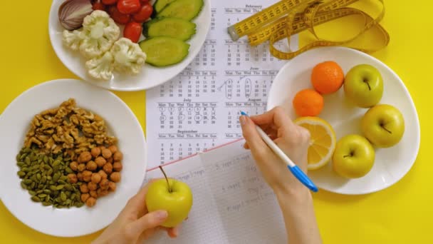 αθλητικό ημερολόγιο, υγιεινό φαγητό, γυρίσματα σε ένα κίτρινο φόντο πάνω όψη - Πλάνα, βίντεο