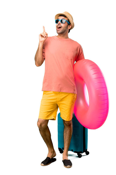 Повне тіло людини з капелюхом і сонцезахисними окулярами на літніх канікулах стоїть і думає про ідею, що вказує палець вгору на ізольований фон
 - Фото, зображення