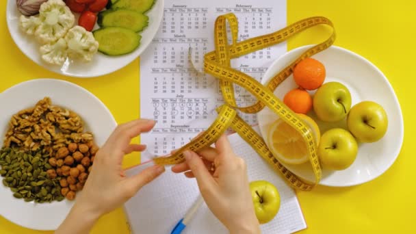 sportovní kalendář, zdravé jídlo, fotografování na žlutém pohledu na pozadí - Záběry, video