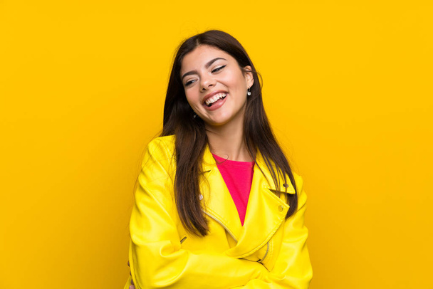 Tiener meisje over gele muur lachen - Foto, afbeelding