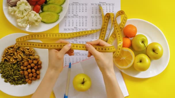 Sportkalender, gesunde Ernährung, Schießen auf gelbem Hintergrund von oben - Filmmaterial, Video